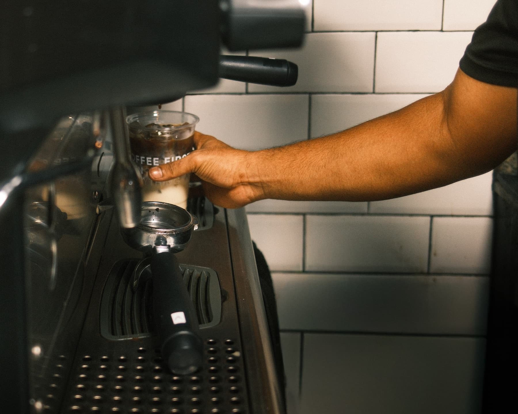 Coffee First team member preparing a drink during a shift